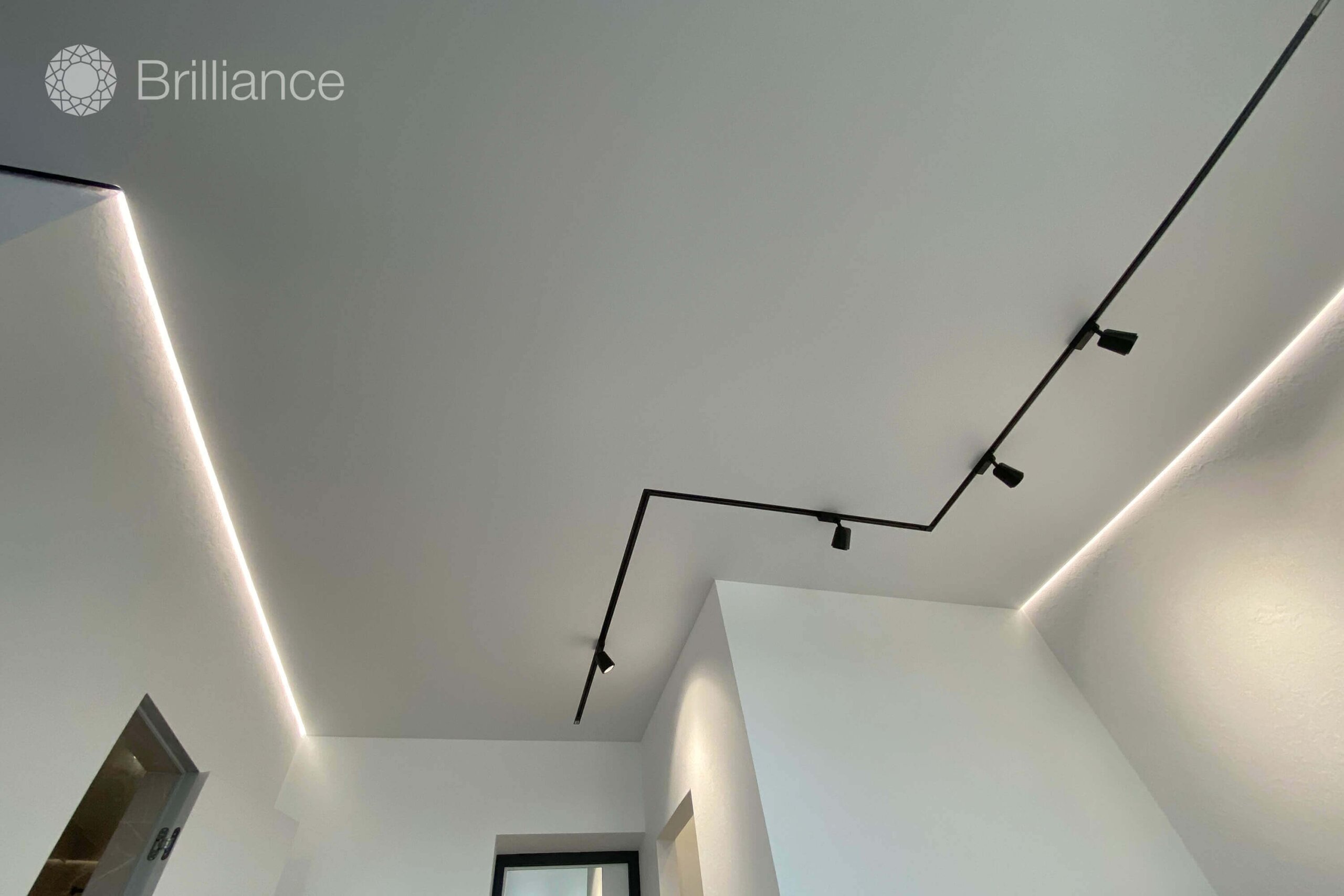 Matte stretch ceiling in the living room with tracks and a floating ...